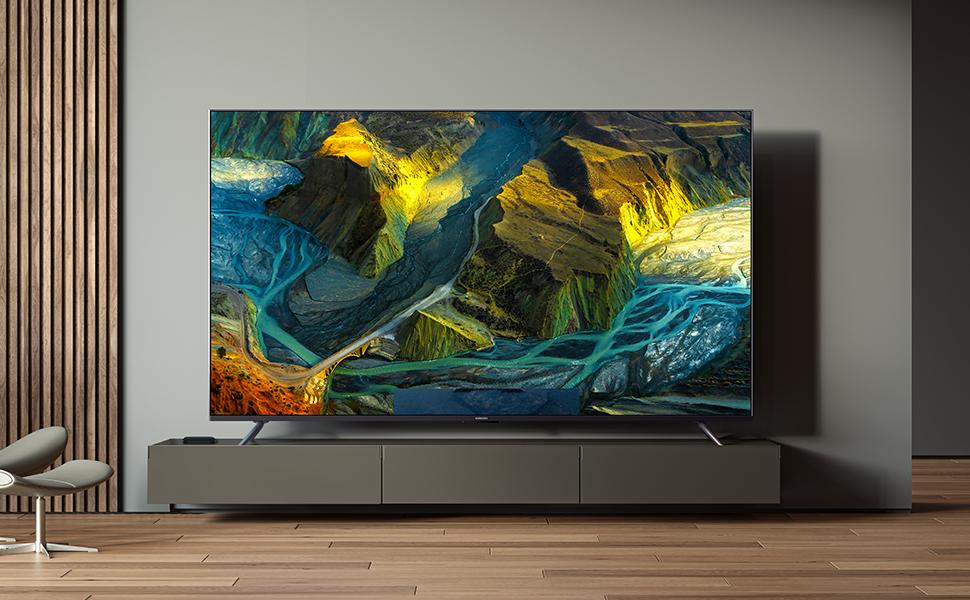 Großer Flachbildfernseher, der an einer Wand montiert ist und ein lebendiges abstraktes Gemälde mit blauen, gelben und grünen Wirbeln zeigt. Der Fernseher befindet sich über einer eleganten Unterhaltungseinheit