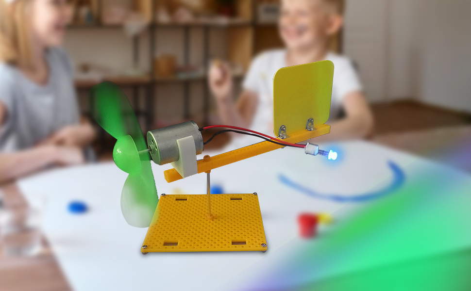 Wissenschaftliches Experimentierset für Kinder mit gelber Basis, Metallstange, grünem Propeller und farbigen Plastikteilen auf einem Tisch. Hände sichtbar, was auf interaktives Spielen hinweist